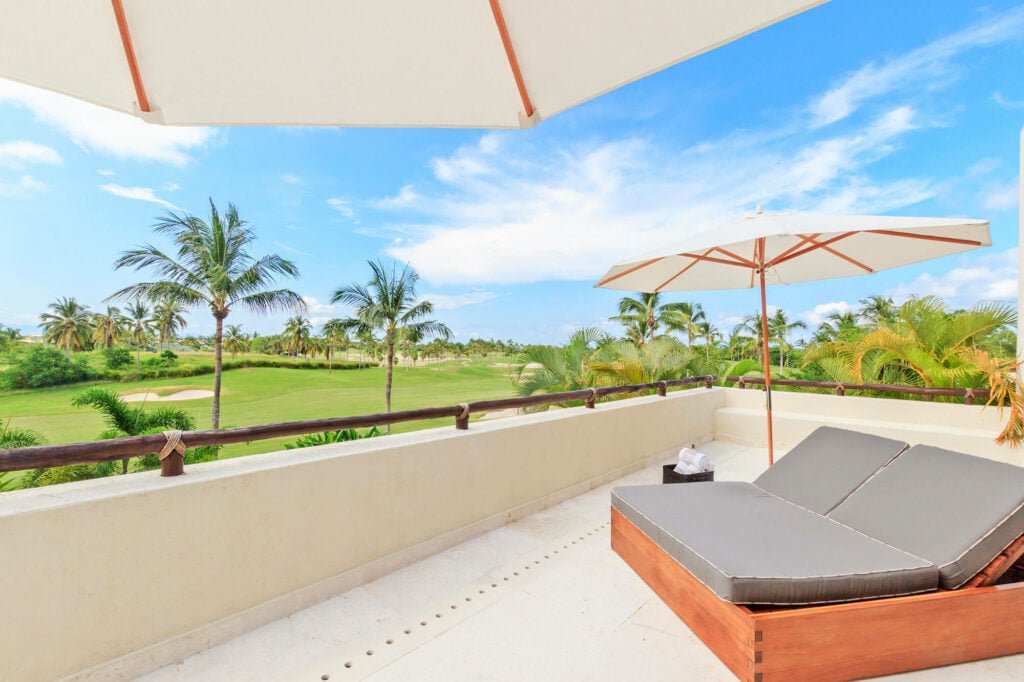 Condo Terramar terrace lounger beneath an umbrella with a golf course view — Punta Mita Nayarit, Mexico