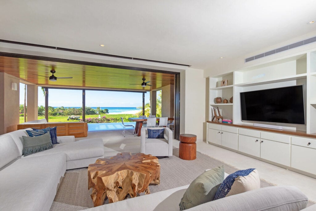 Condo Aquila living room with sectional sofa and doors open to the pool terrace — Punta Mita Nayarit, Mexico