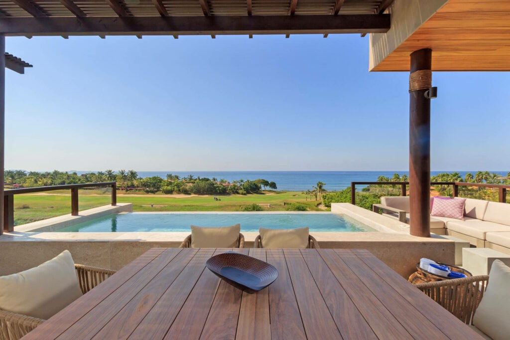 Condo Argo shaded terrace dining table overlooking a pool and ocean — Punta Mita Nayarit, Mexico