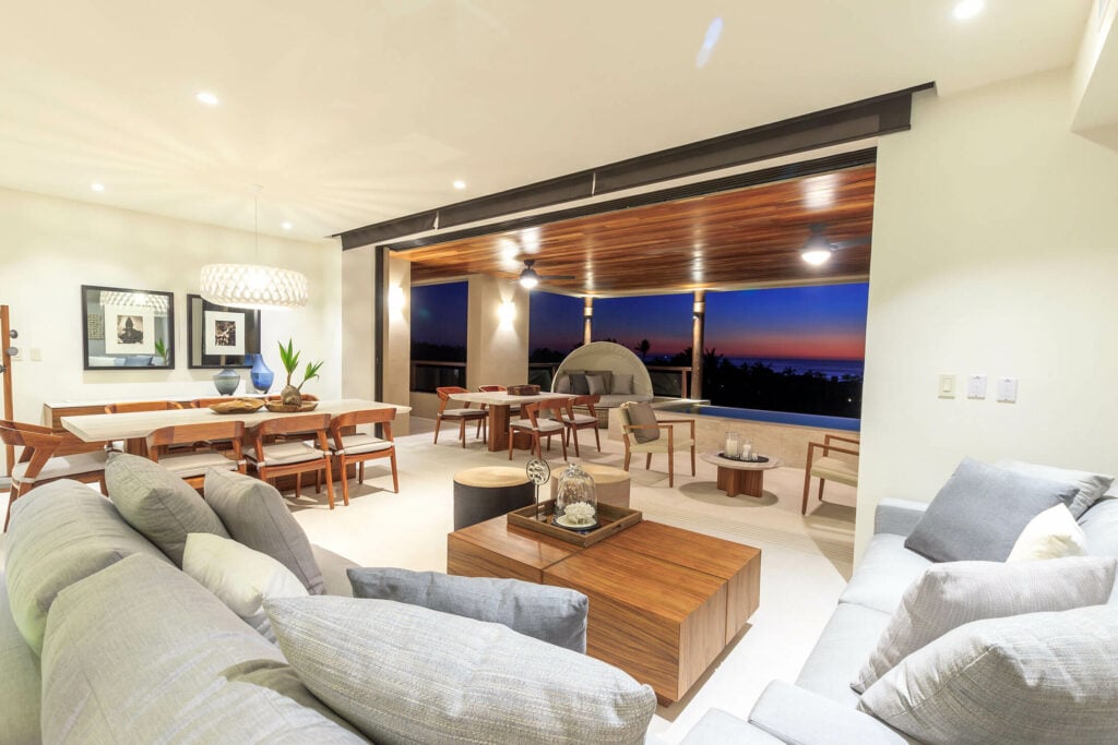 Condo Ceres sectional around a square coffee table with dining room and terrace beyond — Punta Mita Nayarit, Mexico