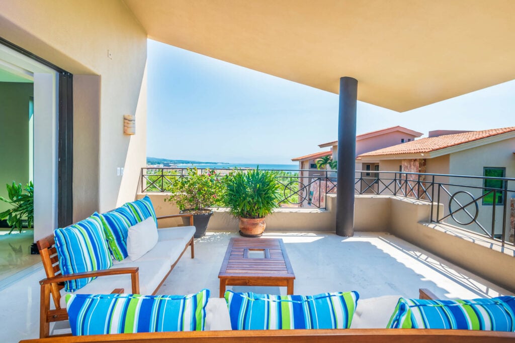 Condo Jazmin terrace sofa with striped cushions beside a potted shrub — Punta Mita Nayarit, Mexico