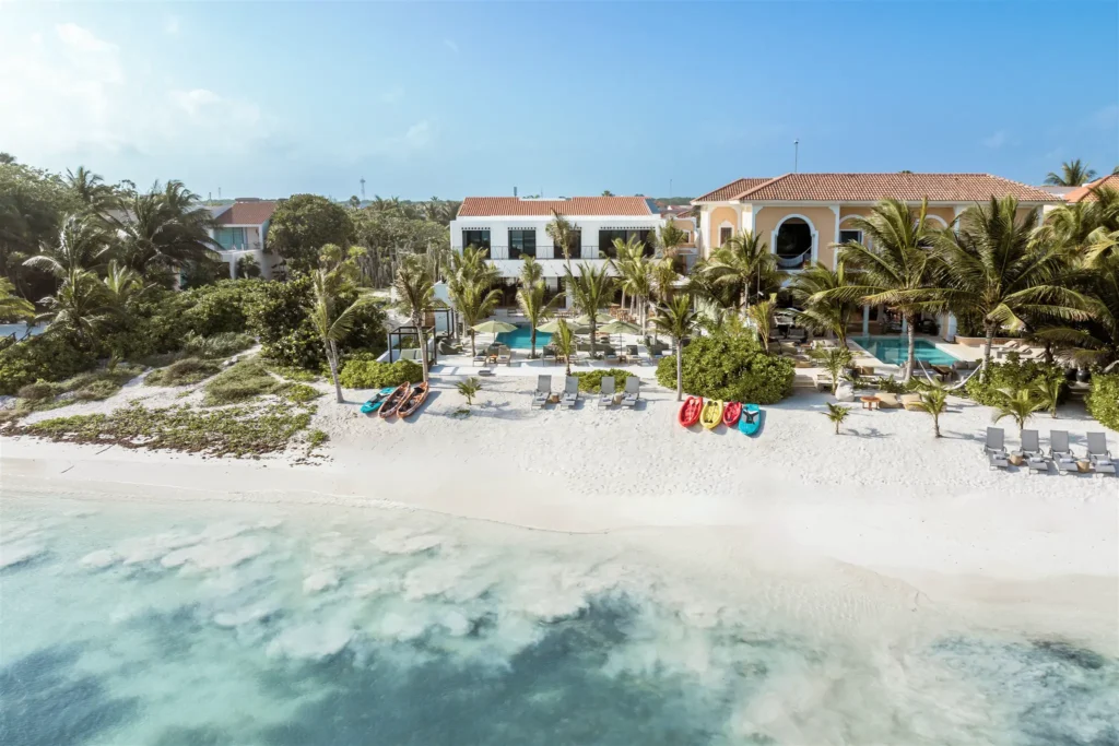 Hacienda Jaguar beachfront with villa buildings, palms and turquoise water — Puerto Aventuras, Mexico