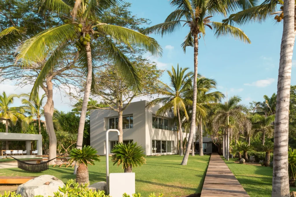 Casa Eterna garden facade and straight boardwalk framed by palm trees — Punta Mita Nayarit, Mexico