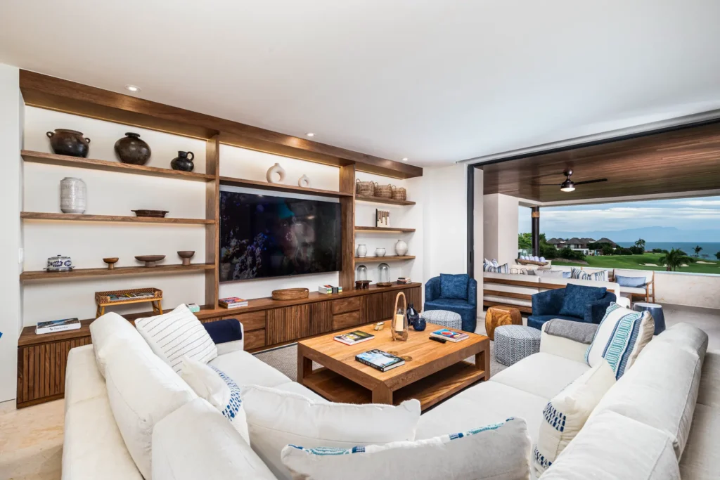 Condo Tau 621 living room with built-in shelves, TV, and sectional seating — Punta Mita Nayarit, Mexico