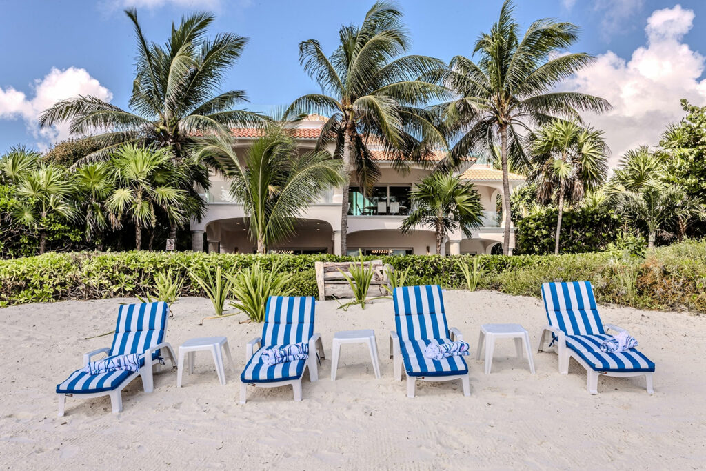 Palacio de Mar striped beach loungers on the sand before the villa — Puerto Morelos, Mexico