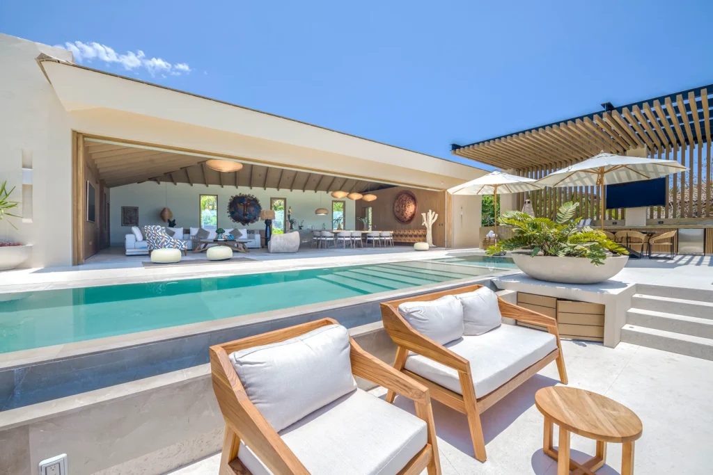 Casa Yeiya wood chairs beside the pool facing the open living and dining area — Punta Mita Nayarit, Mexico