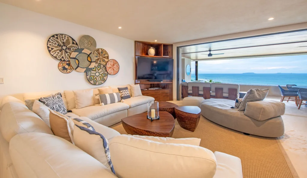 Condo Las Olas living room with a white sectional and open ocean balcony — Punta Mita Nayarit, Mexico