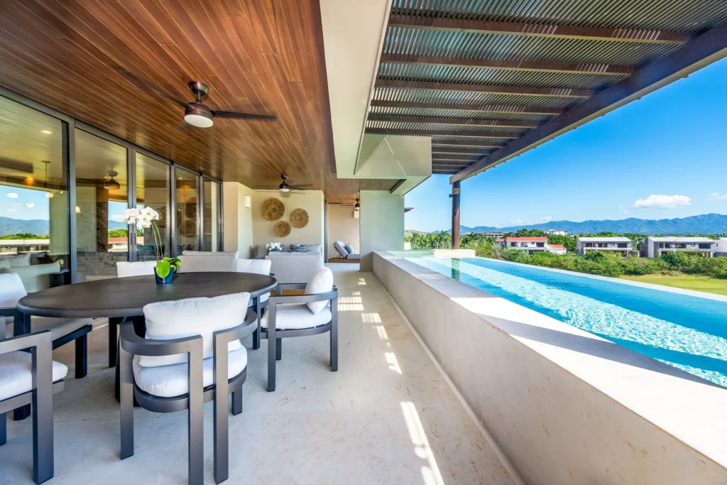 Condo Sardan covered terrace dining table beside the long pool with a mountain view — Punta Mita Nayarit, Mexico