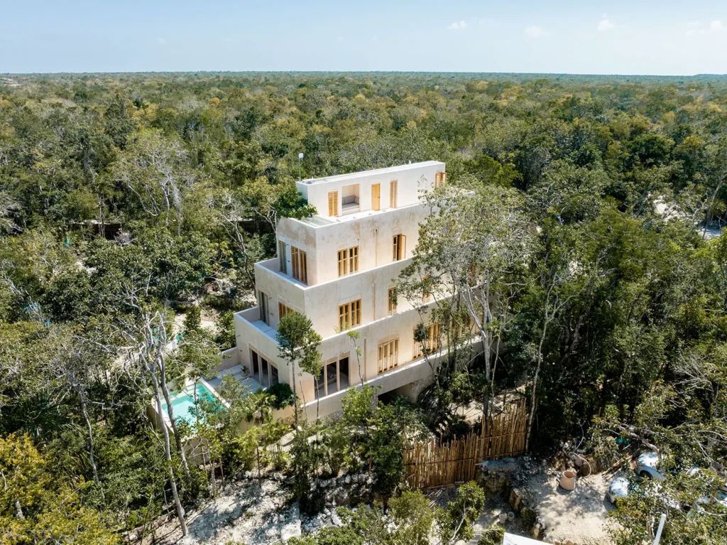 Candela Uno aerial view of the tiered white facade and pool among dense forest — Tulum, Mexico