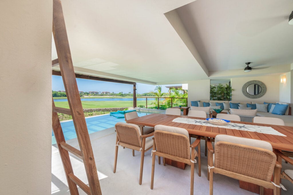 Condo Azul patio dining table beside the pool and blue-cushioned sectional — Punta Mita Nayarit, Mexico