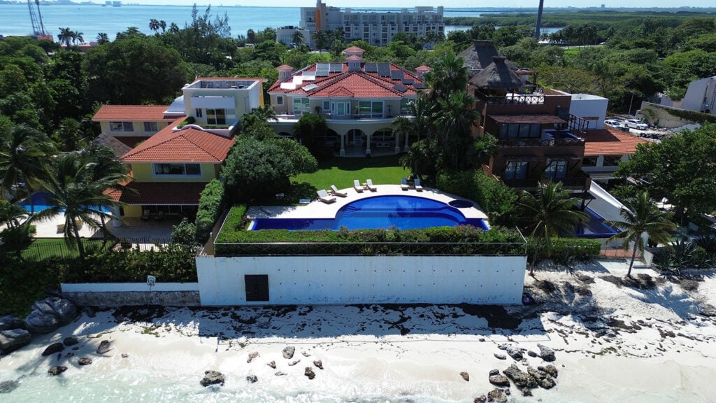 Villa Bianca aerial view of the villa, pool, and rocky shoreline — Cancun, Mexico