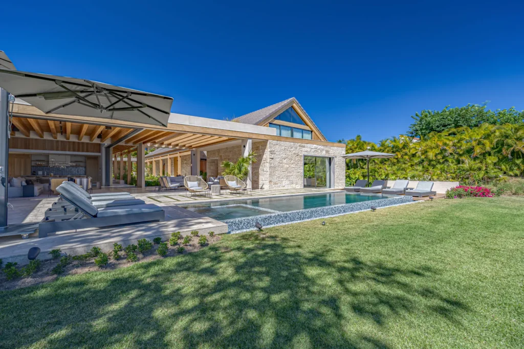 Villa Lagos 11 stone villa and pool seen across a shaded lawn — Punta Mita Nayarit, Mexico