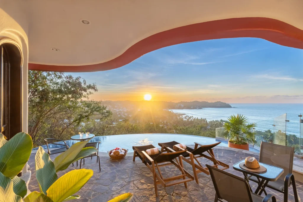 Casa Ensueño sunset pool terrace with wooden loungers and two small tables