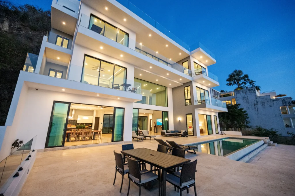 Villa Veva pool terrace with outdoor dining and open living areas at dusk — Puerto Vallarta, Mexico