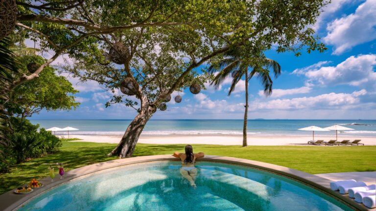 Person relaxing in a round pool at Villa Mandarinas, Puerto Vallarta, Mexico, with ocean and beach views.