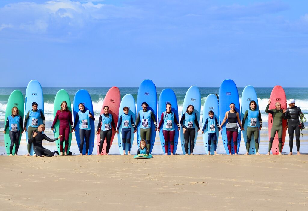 Group of students and instructors holding surfboards during a surf lesson in Punta Mita