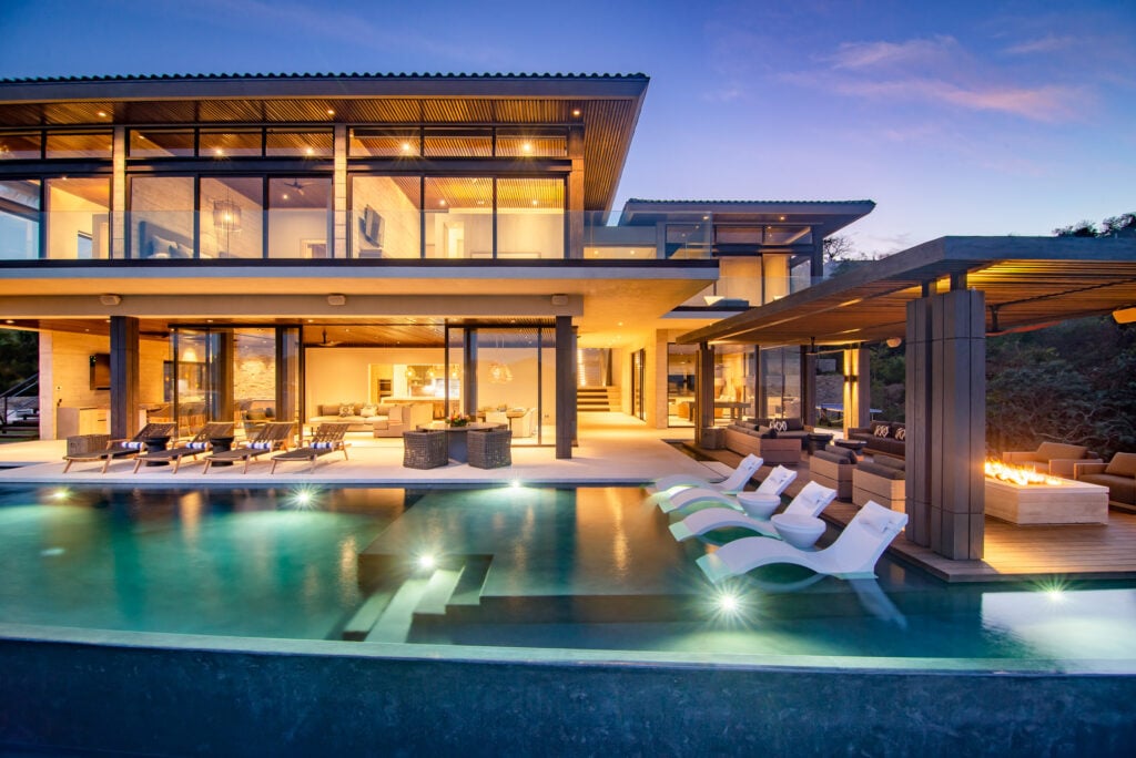 Casa Kupuri 32 the lit house, pool loungers and fire trough at dusk — Punta Mita, Mexico