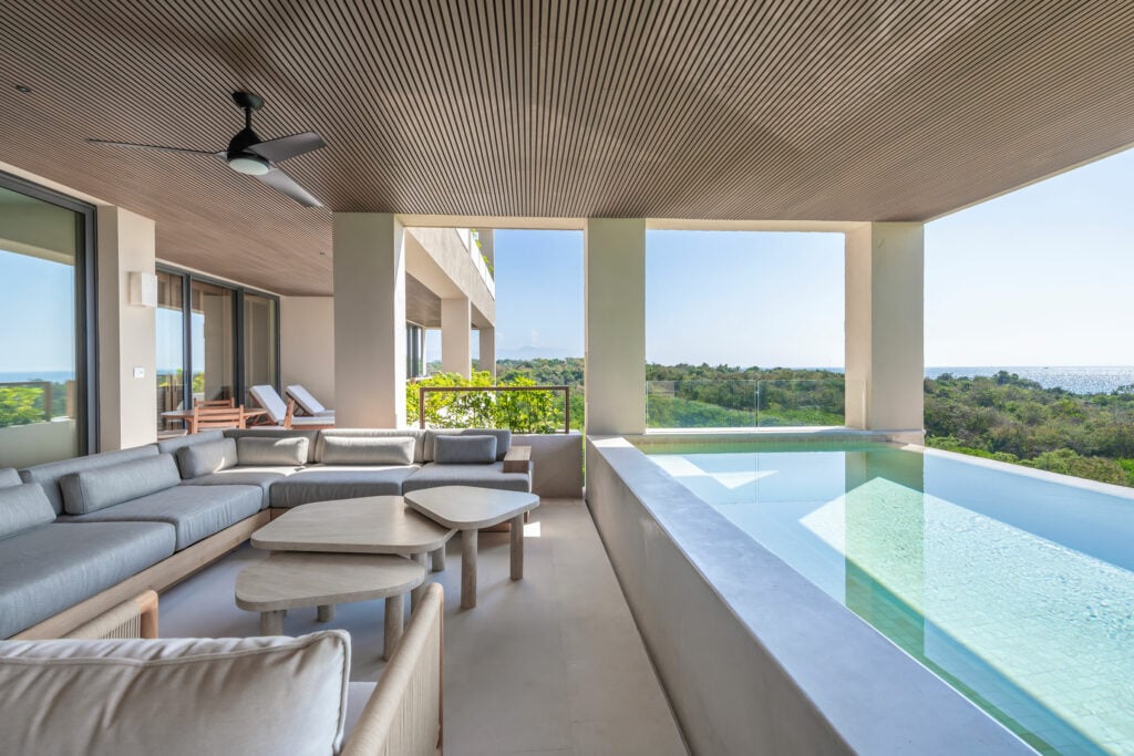 Condo Raya terrace sofas and low tables running the length of the pool — Punta Mita, Mexico