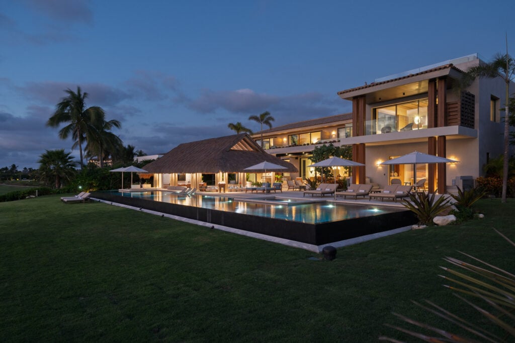 Estate Elementos lit house and palapa reflected in the pool at dusk — Punta Mita Nayarit, Mexico