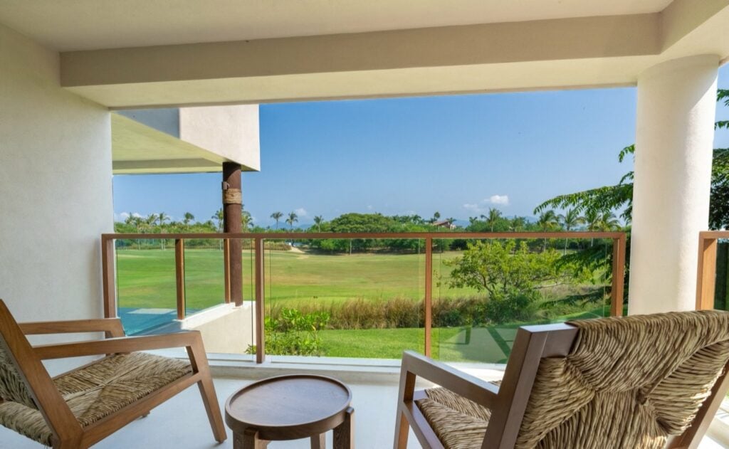 Condo El Encanto 401 two wood chairs and a round table overlooking the lawn — Punta Mita Nayarit, Mexico