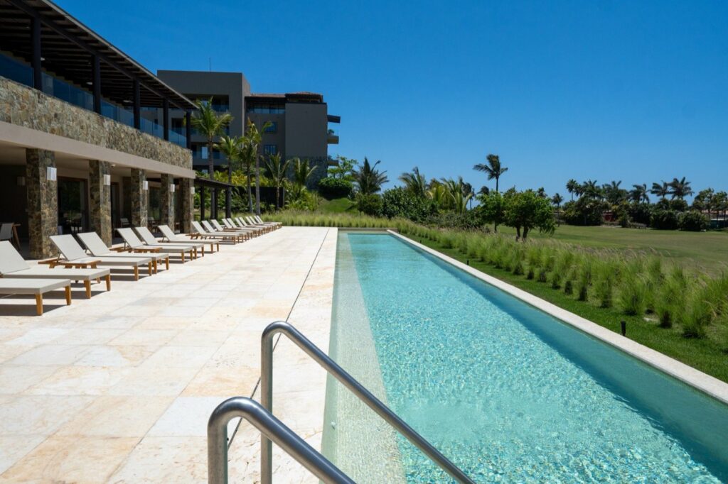 Condo Tau 131 long lap pool with a row of loungers beside the building — Punta Mita Nayarit, Mexico