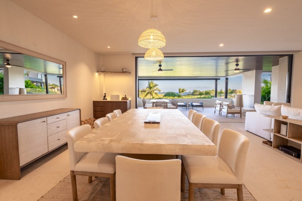 Condo Tau 612 dining table beneath two hanging lamps opening to the terrace — Punta Mita Nayarit, Mexico