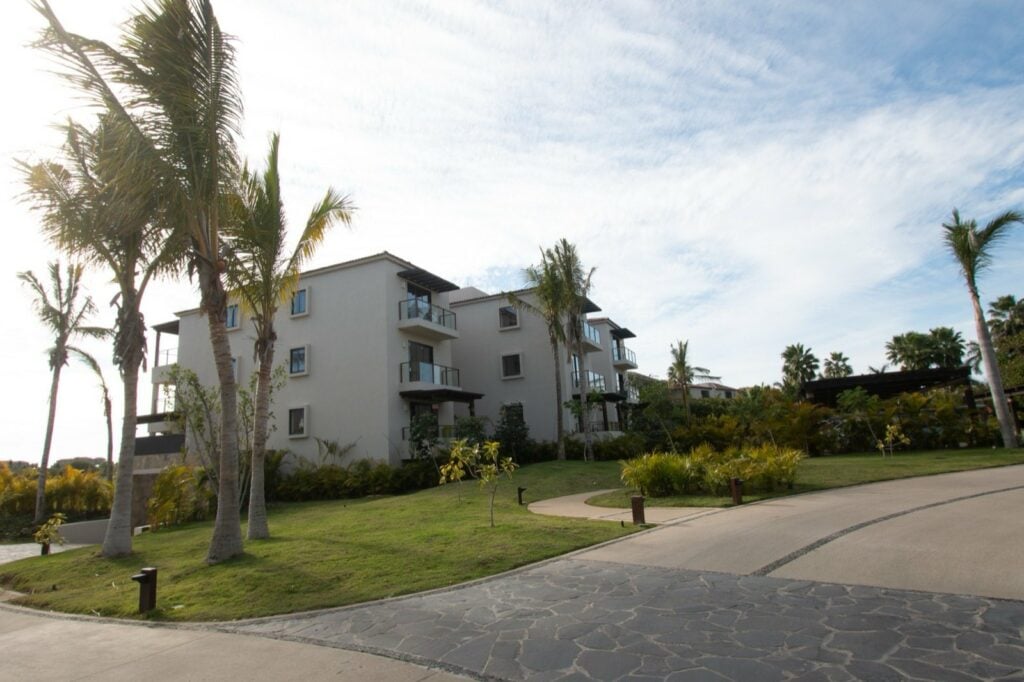 Condo El Encanto 821 exterior of the residence building with palms and paved driveway — Punta Mita Nayarit, Mexico