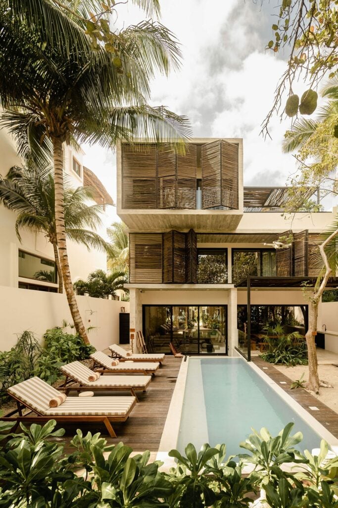 Azumaya Beach House lap pool with striped loungers and bamboo facade — Soliman Bay Tulum