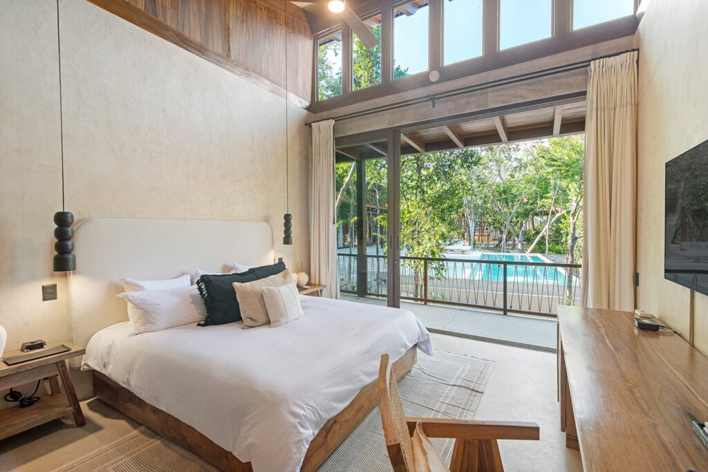 Casa Tropical king bedroom with pool view and sliding glass doors — Region 15 Tulum