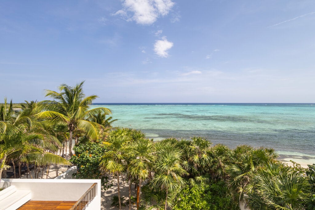 Casa Xixim elevated view over palm trees and turquoise water — Tulum, Mexico