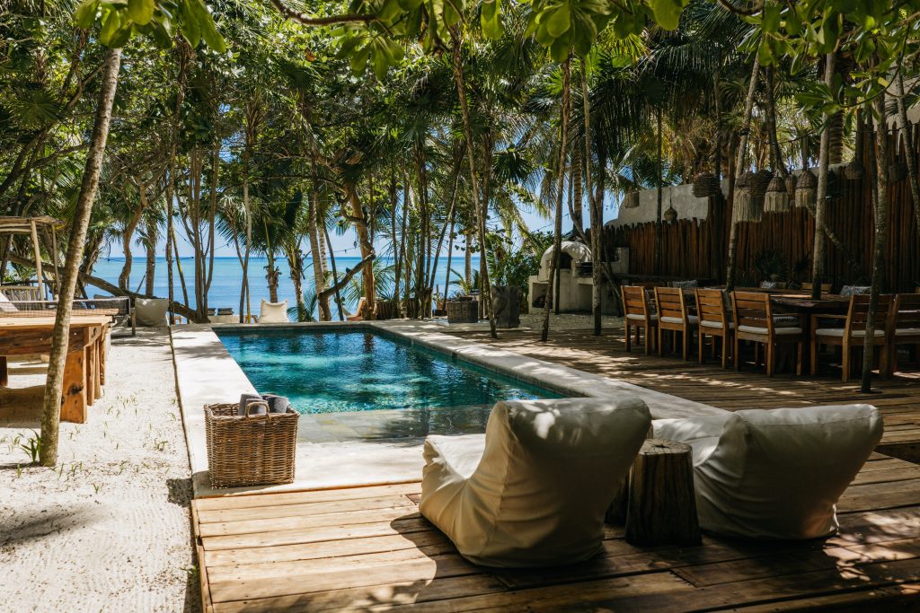 Villa La Semilla rustic bar area with glassware shelves and barn door — Soliman Bay Tulum