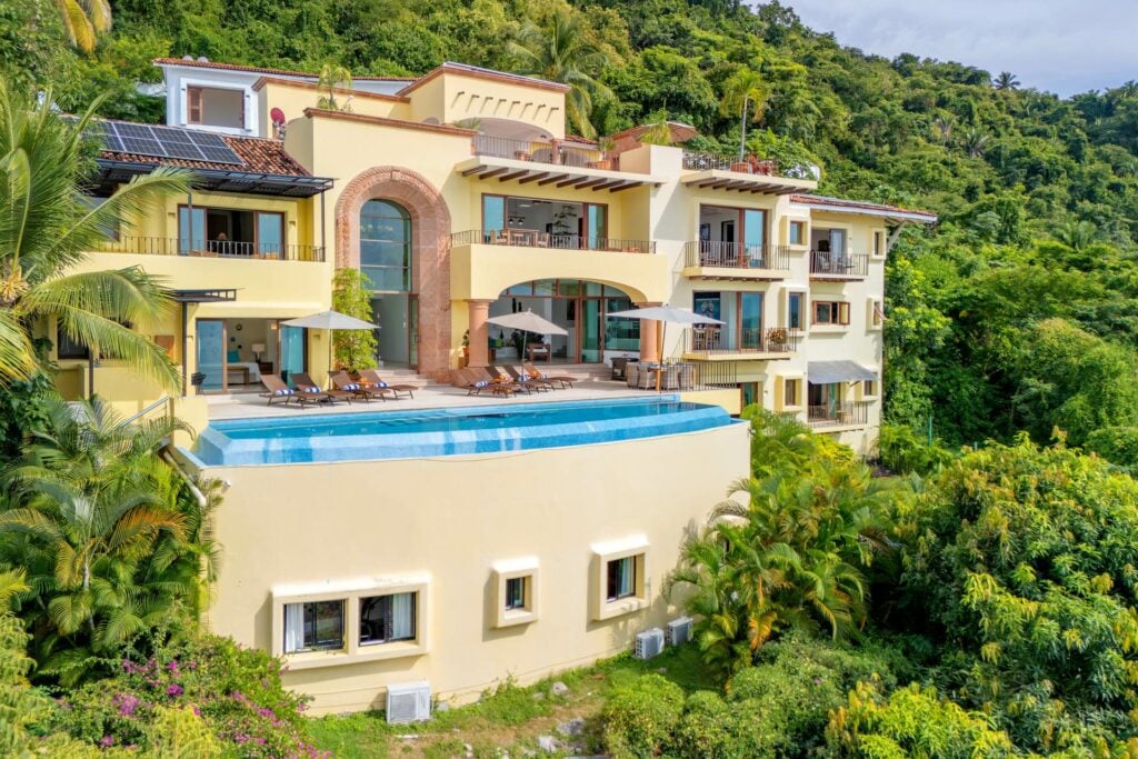 Villa Santa Cruz villa exterior and raised pool surrounded by green hillside — Puerto Vallarta, Mexico