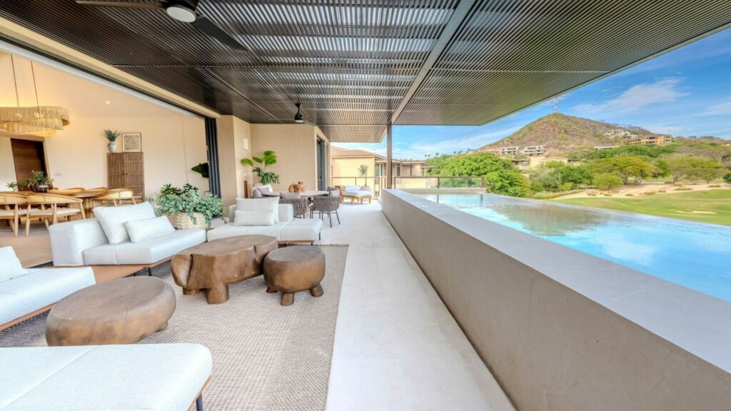 Condo 7 Eight 406 covered terrace seating beside a pool with golf and mountains beyond — Punta Mita Nayarit, Mexico