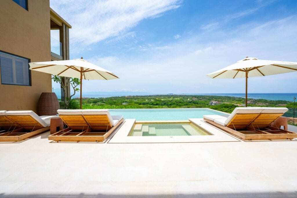 Villa del Sol at Vistas 1 pool terrace with four loungers, umbrellas and a sea view — Punta Mita Nayarit, Mexico