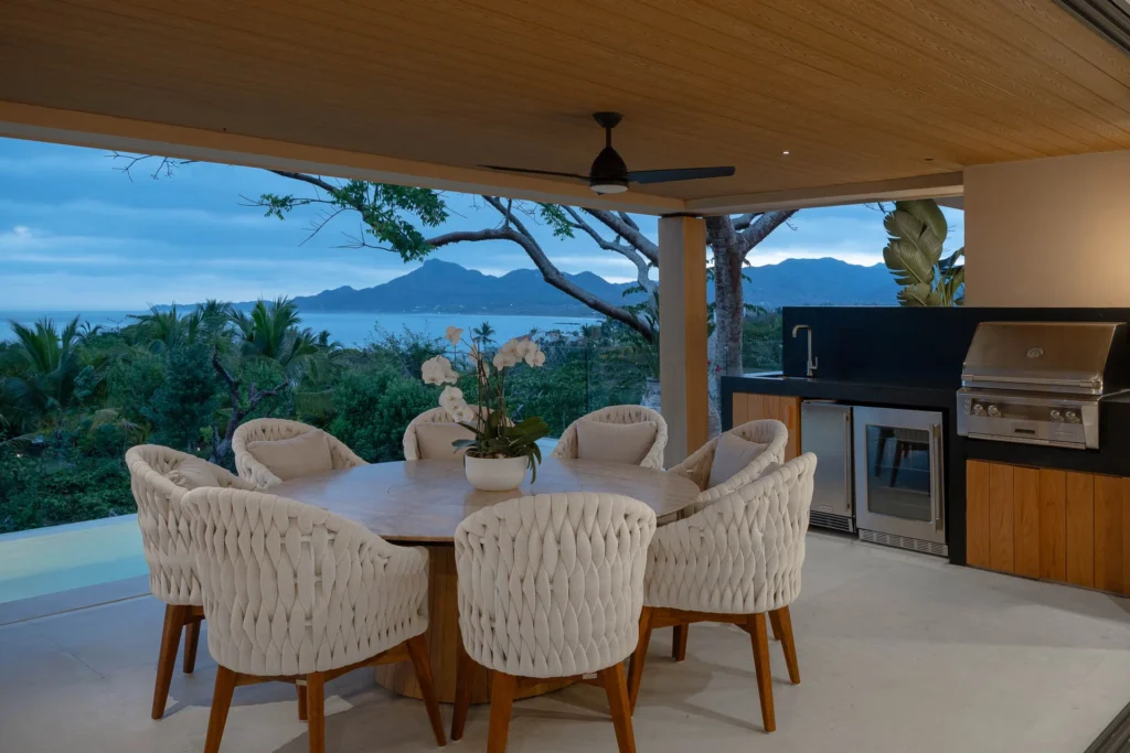 Villa Monarca terrace dining table beside the outdoor kitchen — Kupuri Beach Residences, Punta Mita