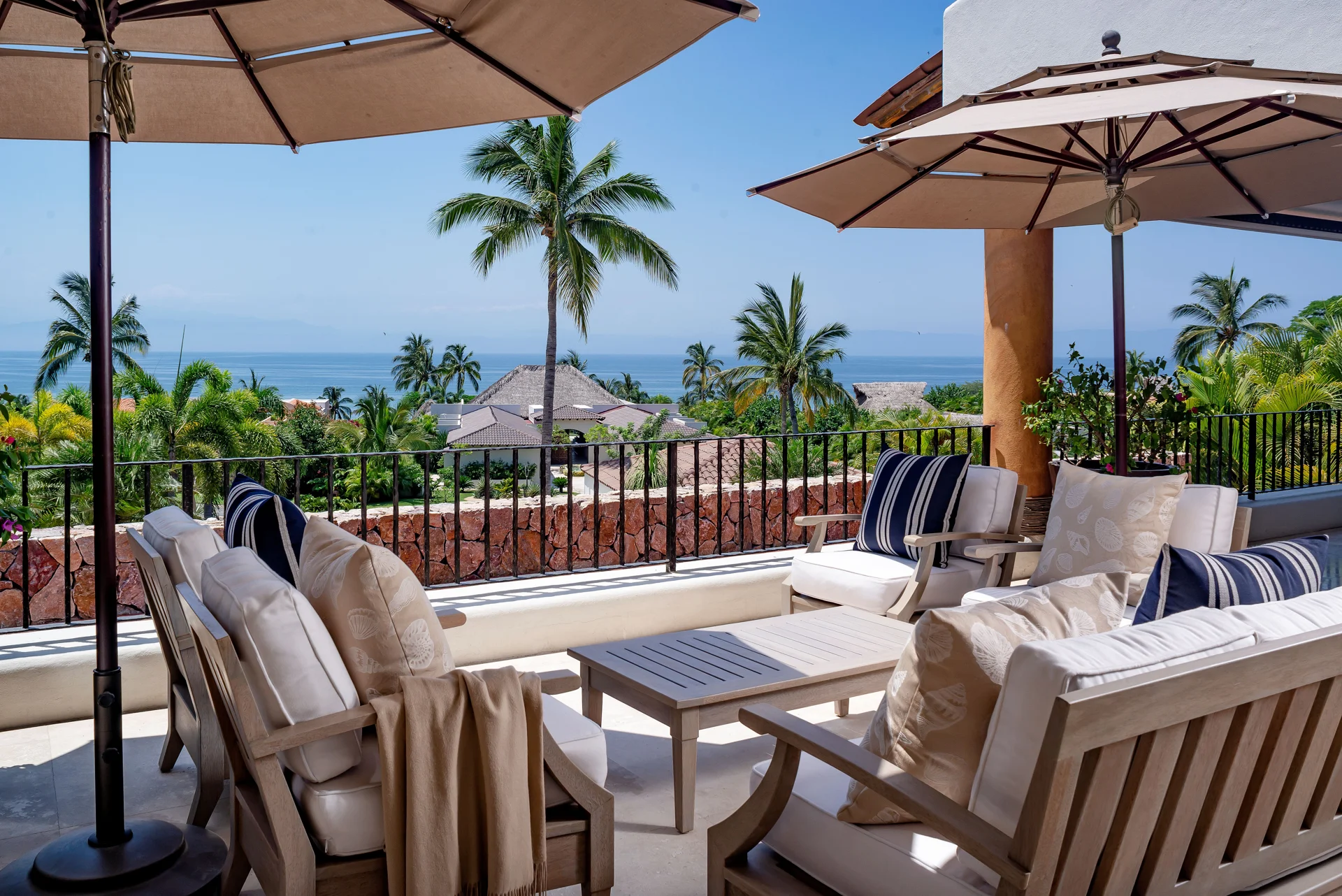 Villa Serena terrace dining with parasols and the ocean beyond — Lagos del Mar, Punta Mita