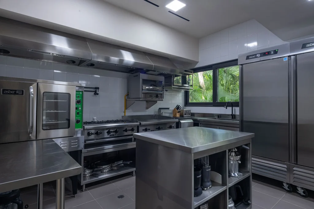 The stainless-steel back-of-house kitchen a staffed villa runs on, with prep stations and commercial refrigeration
