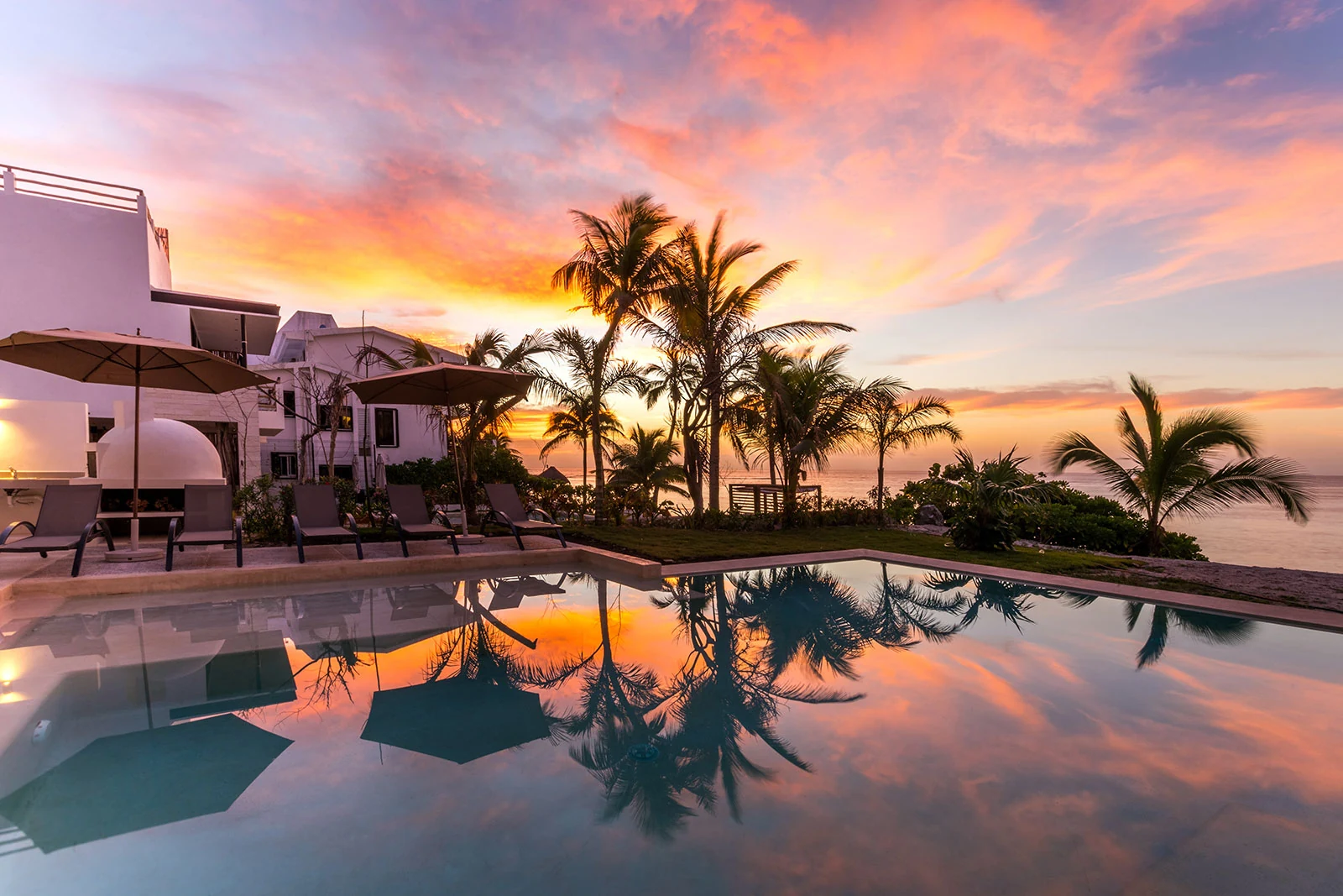 Casa Milah vivid sunset over pool and modern villa — Half Moon Bay, Akumal, Mexico