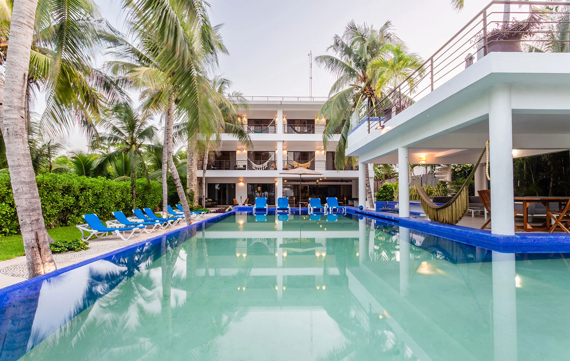 Villa Bellamar infinity pool framed by palms and white villa — Half Moon Bay, Akumal, Mexico