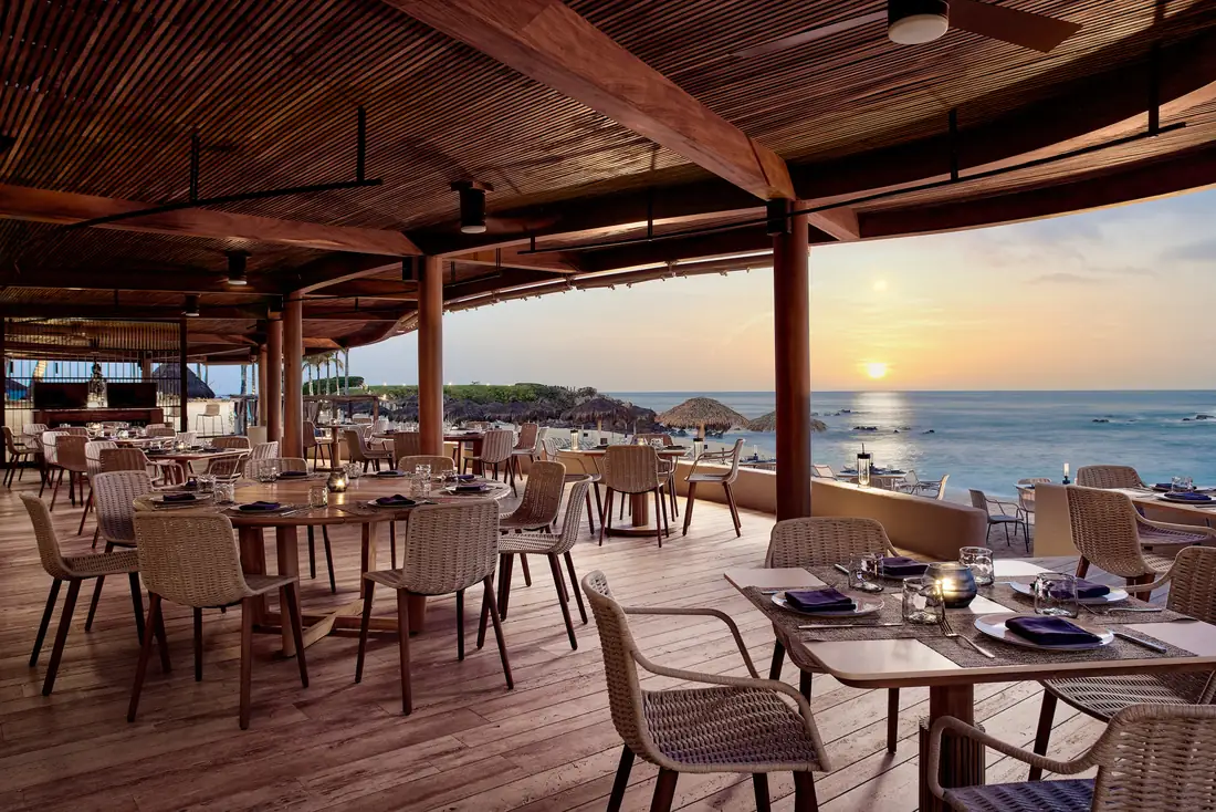 Bahía restaurant at Four Seasons Punta Mita, its dining room open to the beach and a pink sunset sky