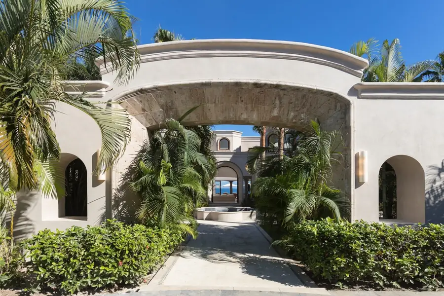 The arched stone entrance to Casa La Vida through a garden, Punta Mita