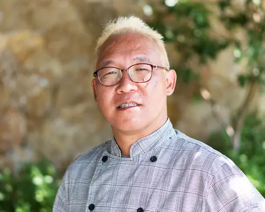 Chef Yasuo Asai of Asai Kaiseki in glasses and a checked chef's jacket