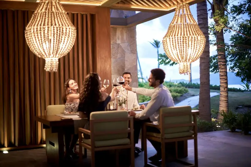 Guests raising a toast under woven chandeliers at Codex, Conrad Punta de Mita
