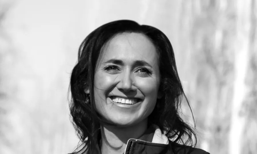 Black-and-white portrait of Laura Catena smiling, with long dark hair