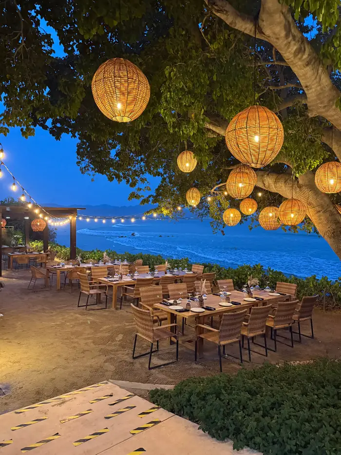 Dinner tables under the trees at Il Molo, Porta Fortuna, Punta Mita