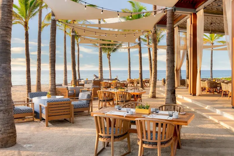 Mezquite's tables on the sand under shade sails and palms, Conrad Punta de Mita