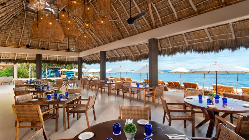 Tables set for lunch under the palapa at Pacífico Beach Club, Punta Mita