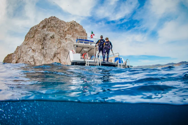 A split shot of the dive boat above the surface and clear blue water below.