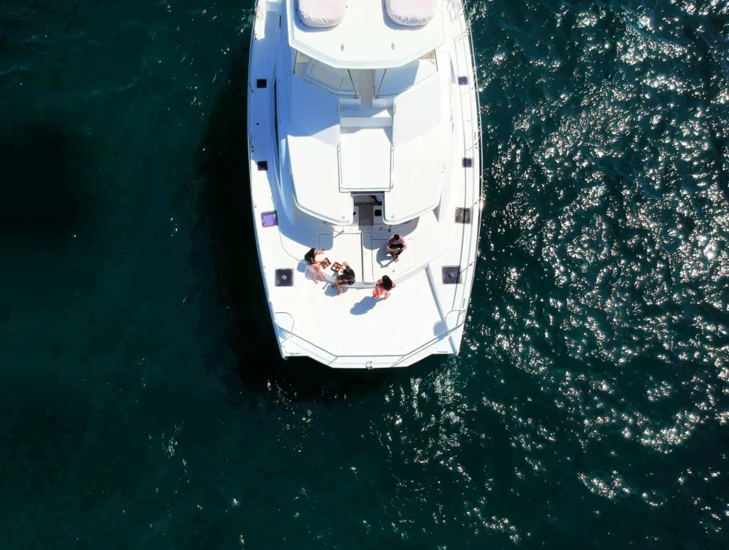 An aerial view looking straight down on the bow of a power catamaran under way.