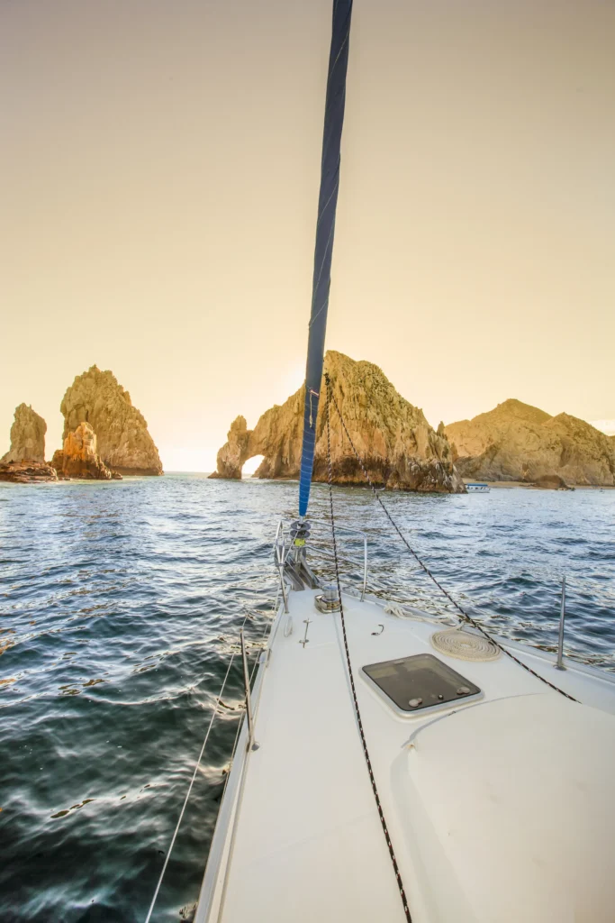 A view along the deck of a sailing boat towards the bow in low evening light.